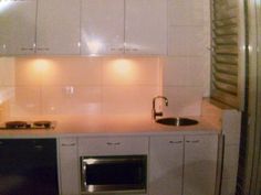 a kitchen with white cabinets and black appliances