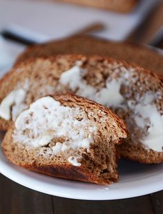 two pieces of bread on a white plate with butter and sour cream in the middle