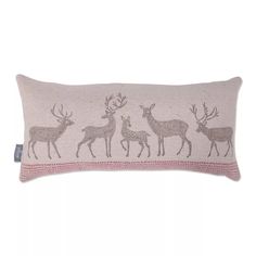 an embroidered pillow with deers and antlers on the front, in grey and pink