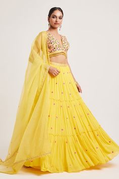 Yellow padded blouse featuring multi-color floral thread and embroidery with tassel detailing on the waistline. Paired with a can-can attached, sequin hand embroidered lehenga with pockets. Comes with a sheer embroidered dupatta. - Aza Fashions Bohemian Summer Lehenga With Floral Embroidery, Summer Embroidered Georgette Lehenga, Summer Floral Embroidery Set For Reception, Diwali Sets With Tassels, Bollywood Choli With Tassels, Festive Choli With Tassels, Diwali Lehenga With Tassels, Tasseled Lehenga For Diwali, Summer Festive Sets With Tassels