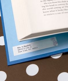 an open book sitting on top of a polka dot tablecloth covered floor with white and blue dots