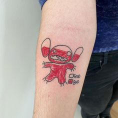 a person with a tattoo on their arm that has a drawing of a cartoon character