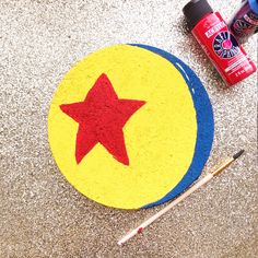 there is a red star on the floor next to some paintbrushes and glue