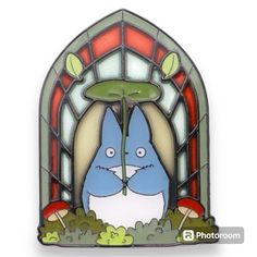 a stained glass window with an image of a blue bunny in the grass and mushrooms