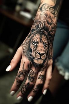 a woman's hand with a tattoo on it and a lion head in the middle