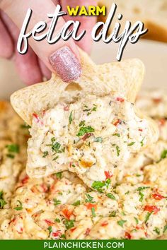 a hand dipping a tortilla chip into a bowl full of feta dip