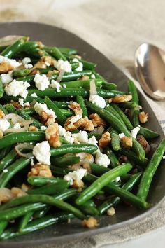 green beans with feta cheese and walnuts in a skillet on a table