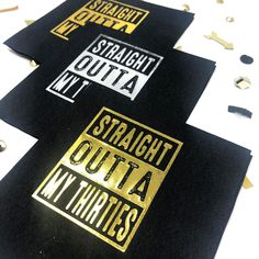 three black and gold coasters sitting on top of a white table covered in confetti