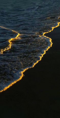 the waves are rolling in on the beach at night, and there is no image here to provide a caption for