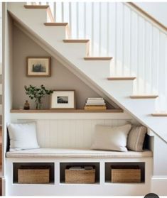 a white staircase with some baskets under it