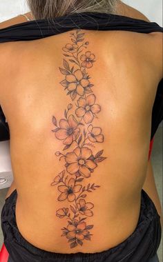 the back of a woman's body with flowers on her lower back and side