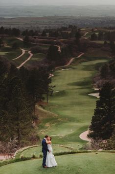 a bride and groom standing on top of a green golf course