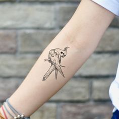 a small bird tattoo on the arm