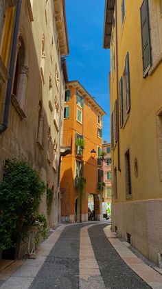 an alley way with buildings and trees on both sides