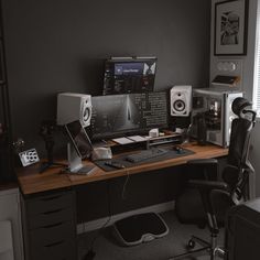 a computer desk topped with lots of computers and speakers on top of it's sides