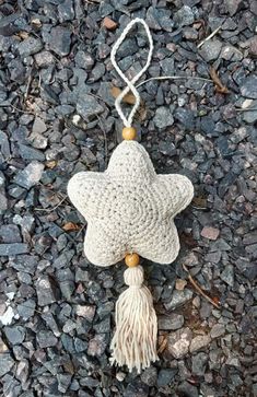 a white crocheted star ornament with tassels on top of it