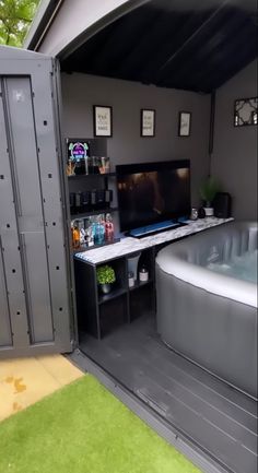 a hot tub sitting inside of a garage next to a tv