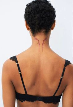 the back of a woman's neck with a tattoo on her left shoulder and chest