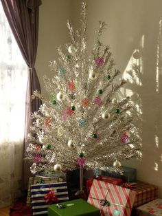 a white christmas tree with presents under it