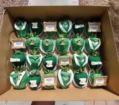 a box filled with cupcakes covered in green frosting