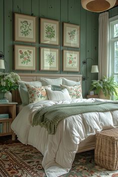 a bedroom with green walls and pictures on the wall above the bed, along with a wicker basket