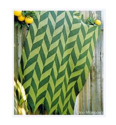 a green and yellow blanket sitting on top of a wooden fence next to lemons