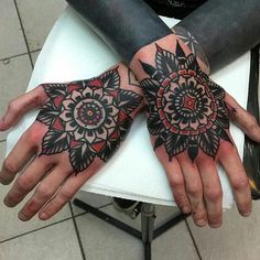 two hands that have tattoos on them and some designs on their palms, both with black ink