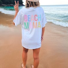 Our FUN + BRIGHT Beach Mama Shirts are perfect for chasing your kids around at the beach. Maybe you're the type of mom who doesn't mind corralling children in your bathing suit. But maybe you're like me and prefer to not risk anything popping/flopping out? Everything stays tucked into place, while still looking sassy in this shirt. Choose from our top quality Comfort Colors Cotton Tee or our Cozy Blend Gildan Hoodie. Both options offer unisex sizing, so size down if you prefer a fitted look, or size up a size or two for an over-sized, ultra comfy fit. Exclusively designed by Parcel 23 Direct to Garment Printed in the USA Choose your style, color and size as you add to your cart. We'll have it produced and delivered in about a week. Any questions or customization to the shirts, please conta Custom Print T-shirt For Beach Vacation, Fun Letter Print T-shirt For Summer, Fun Graphic Print T-shirt For Summer Activities, Graphic Print T-shirt For Beach Season, Summer T-shirt For Beach Season Activities, Cute Multicolor T-shirt For Vacation, Fun Cotton T-shirt For Summer Activities, Multicolor Tops With Text Print For Summer, Multicolor Text Print Tops For Summer