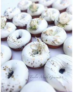 there are many donuts with white frosting and flowers on them