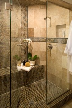 a bathroom with glass shower doors and tiled walls