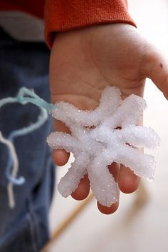 a person holding a snowflake in their hand