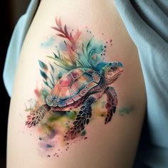 a woman's thigh with a watercolor turtle tattoo on it