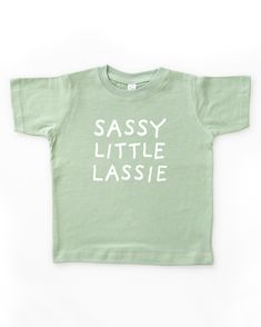 Light sage green short sleeve toddler crew neck tee with white SASSY LITTLE LASSIE print in a handwritten font Playful Soft-washed Cotton T-shirt, Toddler Tshirt Ideas, Neutral Bodysuit, Toddler Graphic Tee, Funny Toddler Shirt, Shirt Quotes, St Patricks Day Shirt, Toddler Humor, Toddler Mom