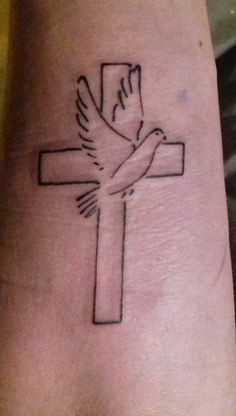 a cross tattoo with a dove on it