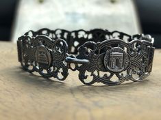 "Antique Art Deco Silver bracelet Souvenir of Paris France Elaborate silver panels featuring landmarks of Paris Arc de Triomphe, Notre Dame, Monmarte, + River Seine Highly detailed embossed repousse details Circa 1920s measures: 7 1/4\" length, fits average size wrist. Very good original antique condition. Please ask questions before purchasing, all sales are final." Heirloom Style Silver Metal Bracelets, Collectible Sterling Silver Antique Bracelet, Victorian Engraved Metal Bracelets, Victorian Sterling Silver Engraved Bracelet, Victorian Sterling Silver Bracelets In Antique Silver, Elegant Silver Jewelry For Souvenir, Elegant Silver Jewelry As Souvenir, Antique Engraved Sterling Silver Bracelets, Antique Sterling Silver Engraved Bracelet