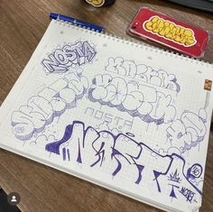 a notebook with some graffiti on it next to a pencil and eraser set up