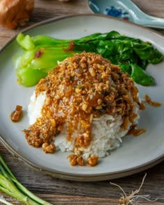 a white plate topped with rice covered in sauce