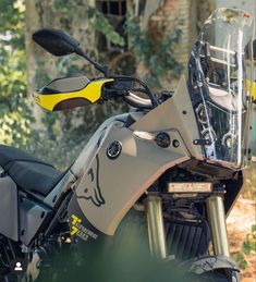 a close up of a motorcycle parked in the woods