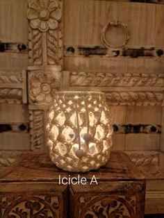 a decorative candle holder on top of a wooden box with the words icicle a in front of it