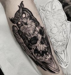 an owl and skull tattoo on the arm