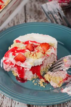 a piece of strawberry shortcake on a blue plate with a fork in front of it