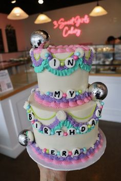 there is a three tiered cake that says happy birthday on the top and bottom