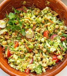 a wooden bowl filled with salad and garnish