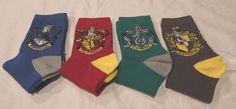 five harry potter socks are lined up in a row on a white sheet with the words, hogwarts