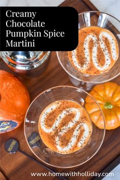 two desserts are sitting on a wooden tray with silverware and an orange pumpkin