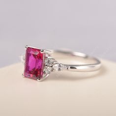 All HANDMADE ITEMS SHIP IN APPROX 8 DAYS Main Stone: Lab created ruby Main Stone Size: Emerald cut 6 mm x 8 mm Main Stone Weight: 1.75 carat Side Stone: CZs Height From The Ring Setting Bottom(to gemstone top): about 5.13 mm Width of Ring band Measure: gradually varied,about 1.67 to 1.91 mm Material: .925 Sterling Silver/14K White Gold/14K Yellow Gold/14k Rose Gold Engraved: Available For FreeNo more than 13 letters) Customized:Of course! Tell me what you want Includes With Order: All of my stor Pink Ruby Birthstone Ring With Prong Setting, Formal Lab-created Ruby Birthstone Ring With Accent Stones, Formal White Gold Ruby Ring With Birthstone, Ruby Birthstone Ring With Pink Center Stone, Formal Lab-created Ruby Diamond Ring With Birthstone, Formal Lab-created Ruby Birthstone Diamond Ring, Ruby Promise Ring With Diamond Cut, Ruby Ring With Diamond Cut For Promise, Emerald Cut Ruby Birthstone Ring With Center Stone