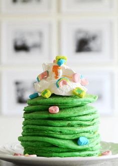 a stack of green pancakes with white frosting and sprinkles on top