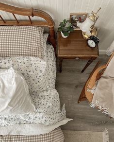 an overhead view of a bed with pillows and blankets on it, next to a night stand