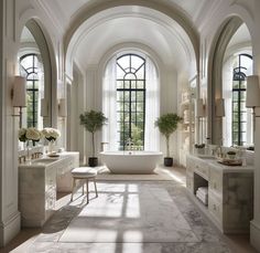 an elegant bathroom with arched windows and marble flooring