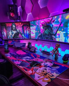 a gaming room with several monitors and games on the wall, including alien man figures